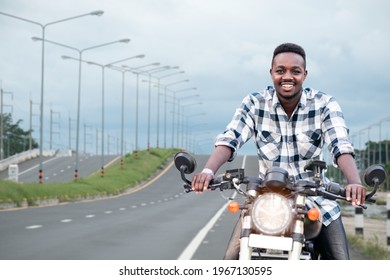 African Biker Man Riding A Motorcycle Rides On Highway Road