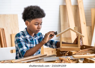 African Black Boy Child Kid Carpenter Sanding Wood With Sandpaper In Carpentry Workshop. Concept Hobby At Home.