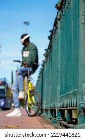 African Black Boy Listening To Music With The Helmets On The Bike. Urban And Street Scenery On A Bridge