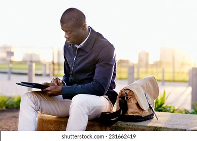 African black business man hipster using tablet computer in park on break from work - Powered by Shutterstock