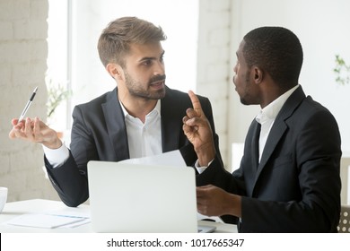 African black client having claims about business document disagreeing with caucasian partner, stressed diverse businessmen arguing in office disgruntled by bad contract or obligations noncompliance