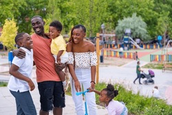 African Black Ethnicity Family Having Fun With Happy Children Together In Playground, Greeting Each Other After School