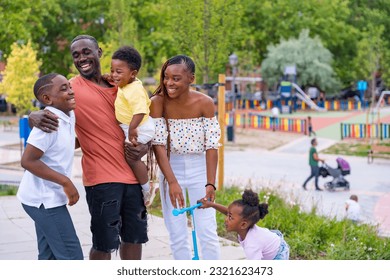 African black ethnicity family having fun with happy children together in playground, greeting each other after school - Powered by Shutterstock