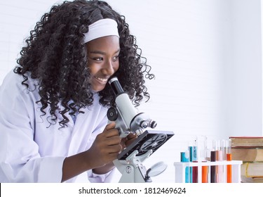 African Black Girl Studying Science And Using Microscope In Classroom At School. Education And Diversity Concept.