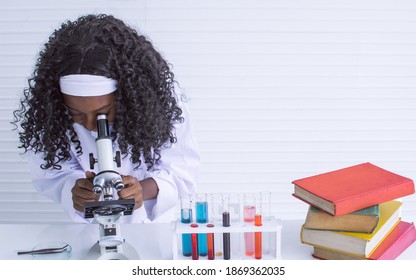 African Black Girl Studying Science And Using Microscope In Classroom At School. Education And Diversity Concept.