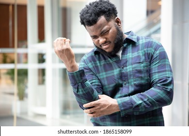 African Black Man Suffers From Elbow Joint Pain Or Arm Bone Osteoporosis; Concept Of Tennis Elbow Or Golfer’s Elbow Symptoms