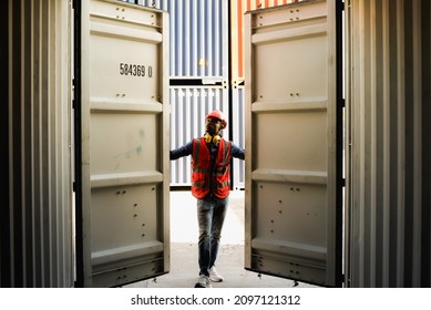 African black man worker wearing safety work equipment clothes are Working and opening containers checking goods in containers at a port warehouse, cargo, import, export and industry concept.
