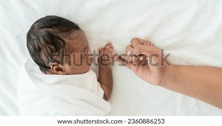 African black parent hands holding newborn baby fingers, Closeup mother’s hand holding their new born baby day. Together love harmony family nursery healthcare and medical father’s day concept banner