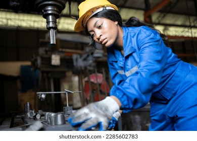 African black woman wearing blue safety uniform working control with heavy machine in factory - Powered by Shutterstock