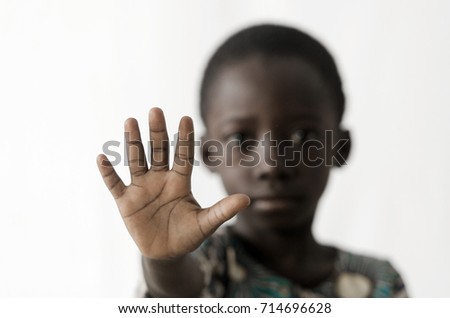African boy makes a STOP sign with his hand, isolated on white