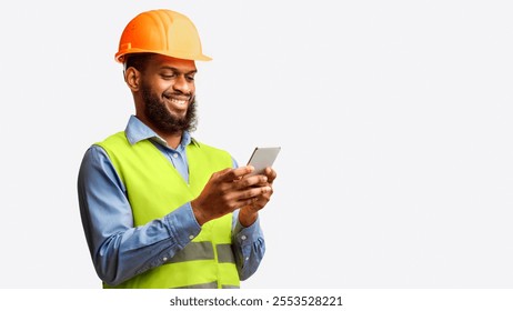 African Builder Worker Using Smartphone Building App Standing On White Studio Background. Panorama, Copy Space