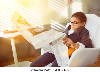 African business kid reading the newspaper as a manager in the office