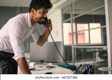 African Business Man Having Conversation On Landline Phone. Business Man In Office.