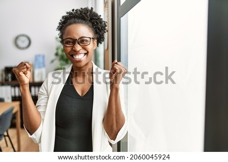 African business woman working at the office screaming proud, celebrating victory and success very excited with raised arms  Foto d'archivio © 