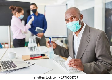 African Businessman Disinfecting With Mask And Cleaning Supplies In The Office At Work