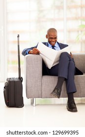 African Businessman Reading Newspaper In Airport Vip Lounge