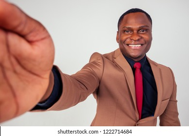 African Businessman Snow-white Smile Using Phone Photographing Selfie In Brown Suit, Black Shirt And Red Tie On White Background In Studio Shot