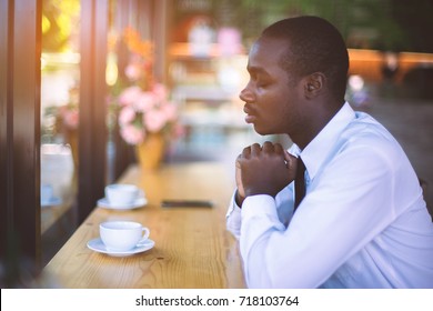 African Businessman spiritual peaceful praying and wishing in coffee shop.
