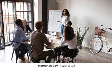 African businesswoman coach presenter give whiteboard business presentation in modern office boardroom, female speaker trainer speaking teach diverse team group people at corporate meeting training - Shutterstock ID 1536455102