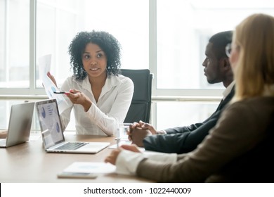 African businesswoman showing good statistics report explaining deal advantages convincing multiracial partners at negotiations meeting, black manager consulting diverse clients promising benefits