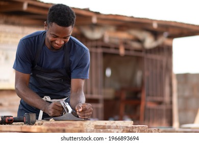 African Carpenter Smiling While Working