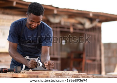 african carpenter smiling while working