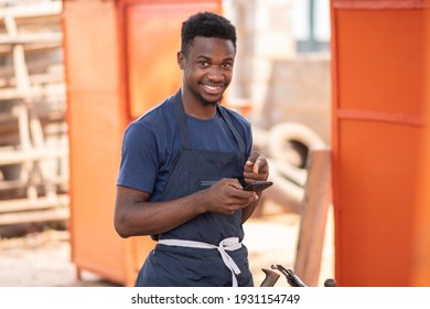 African Carpenter Using His Phone