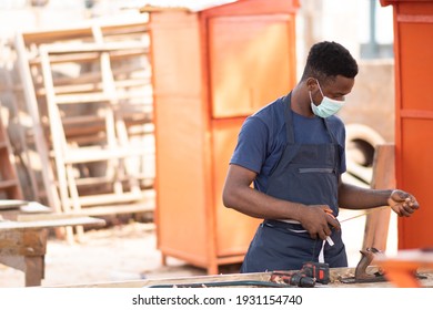 african carpenter wearing a face mask at work - Powered by Shutterstock