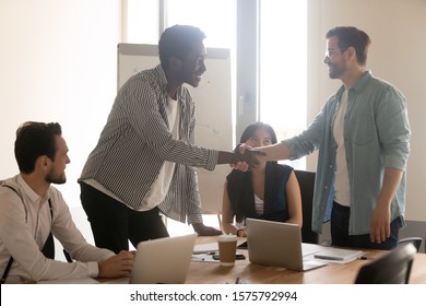 African and Caucasian ethnicity businessmen shake hands after closing deal accomplish successful negotiations, executive manager handshake with client satisfied with effective group meeting concept - Shutterstock ID 1575792994