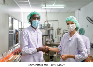 African And Caucasian Lab Specialist Shake Hand For Cooperation In Quality Assurance Of Production In Beverage Industry Factory