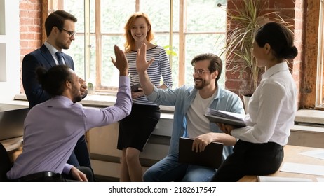 African and Caucasian workmates diverse buddies friends giving high five gesture making agreement during group briefing in office. Make a bet or wager, partnership, support, racial equality concept