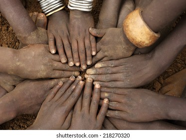 African ceremony of the Mursi tribe, close-up of hands of a group of children, Ethiopia