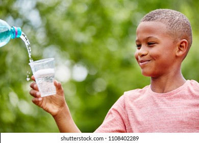 African Child Holding Plastic Cup Excited About Drinking Water