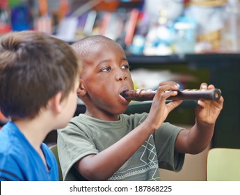 African Child Playing Flute In A Music School