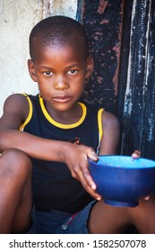 African Child Portrait In A Village In The Rural  Botswana Eating  In Front Of The House