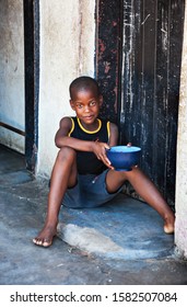 African Child Portrait In A Village In The Rural  Botswana Eating  In Front Of The House