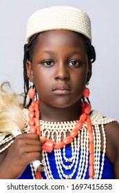 An African Child Wearing An Ewu-Ivie And Ivie-Uru, The Traditional Dressing Of West African Tribe In Benin, Edo State On A White Background