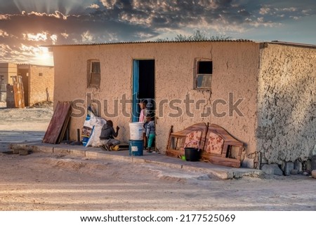 African children in front of the house at sunset