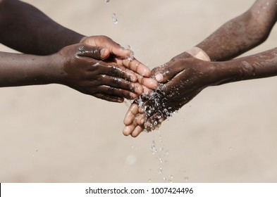 African Children Washing Their Hands With Water Outdoors