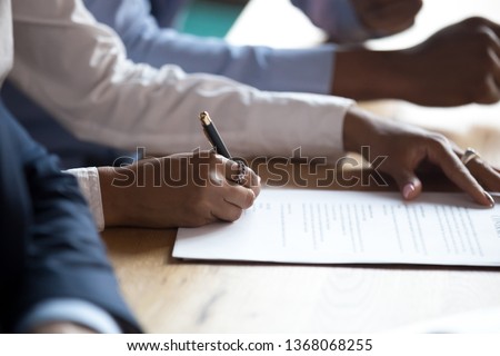 African client customer hand sign business contract at meeting, get hired make sale purchase deal write signature on document employment agreement, take bank loan buy insurance service, close up view