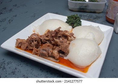 African Corn Meal Pap Staple Food, Goat Stew And Pumpkin Leaves