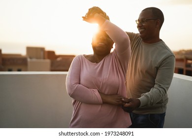 African couple dancing outdoors at summer sunset - Focus on man face - Powered by Shutterstock