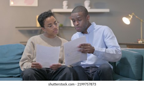 African Couple Reading Documents At Home