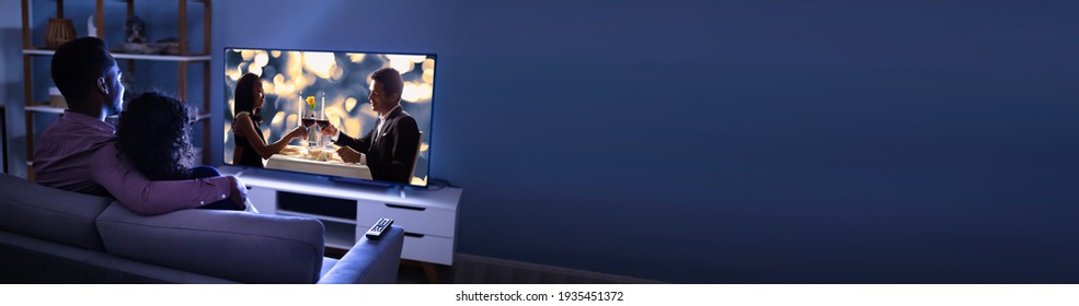 African Couple Watching TV Movie On Television Screen Online