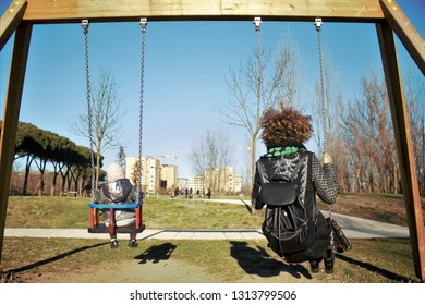 African Creole Mom And Daughter On The Swing At The Playground