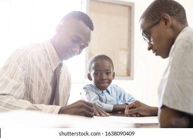 African Dad Father And Child Son Signing Contract For Back To School Or For An Adoption Process, Candid Authentic Picture
