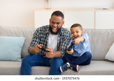 African Dad And Son Bonding Playing Video Game At Home