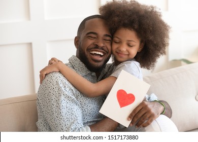 African daddy on Father Day received from caring little daughter paper postcard written message best wishes, drawn red heart as symbol of love and deep affection, family holidays celebration concept - Shutterstock ID 1517173880