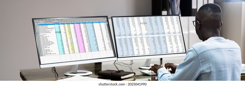 African Data Analyst Man Using Spreadsheet On Computer