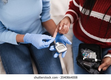 African daughter makes blood glycemia test for diabetes check at home - Focus on glucometer